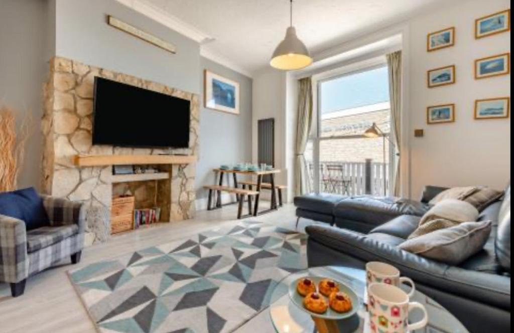 een woonkamer met een bank en een tv bij Ocean view in Swanage