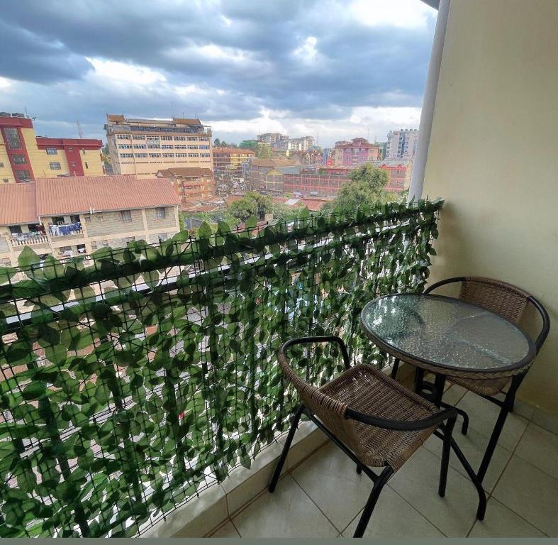 a balcony with a table and chairs and a window at Habun Homes in Ruaka