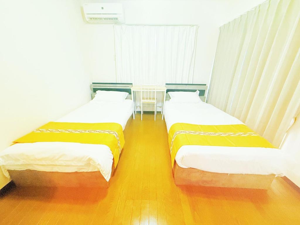 two beds sitting next to each other in a room at Jaunty 130 Room 205 in Fukuoka