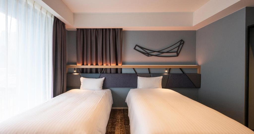 Una cama o camas en una habitación de QuintessaHotel Osakaumeda Comic&Books