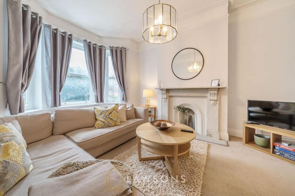 ein Wohnzimmer mit einer Couch, einem Tisch und einem Kamin in der Unterkunft Luxury 5BR Villa I Central & Free Parking in Windsor