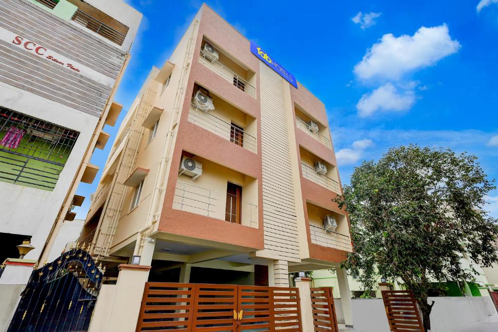 een hoog gebouw met een hek ervoor bij FabHotel Sejour Royal in Chennai