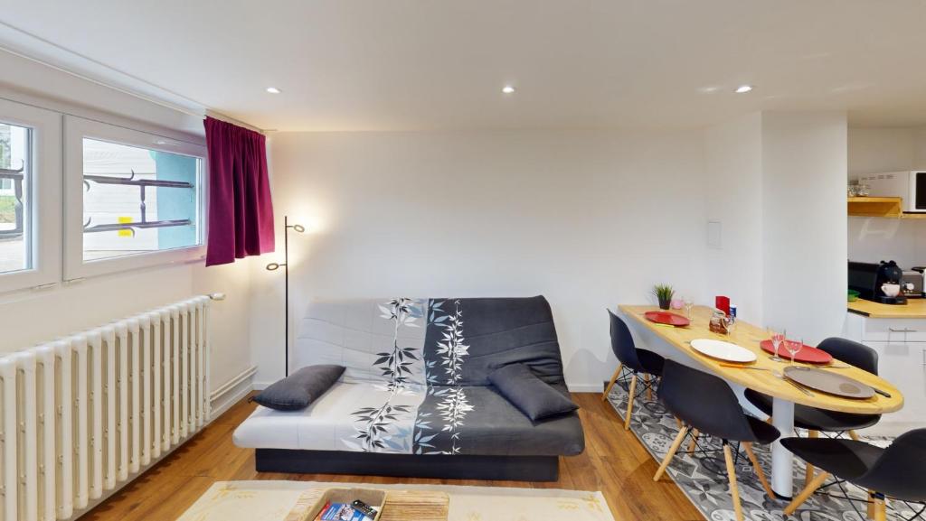 a living room with a couch and a table at L'intime in Dingsheim