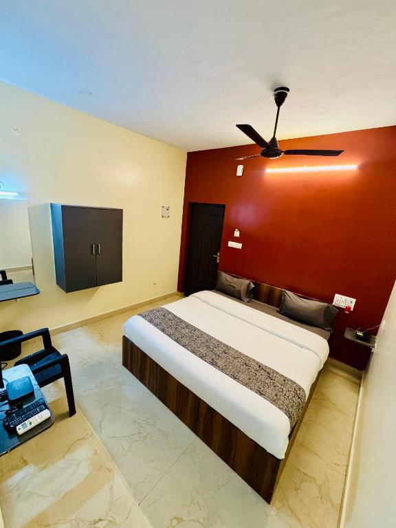 Un dormitorio con una cama con una pared roja. en Olive By David Residency - Just 4 Kms from Meenakshi Amman Temple, en Madurai