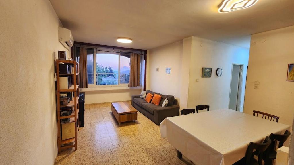 a living room with a table and a couch at The Nest in the Tower in Safed
