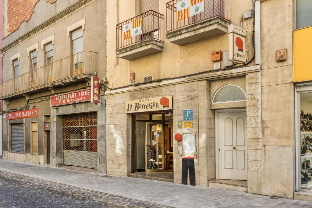 a building with shops on the side of a street at Hostal la Barretina in Figueres
