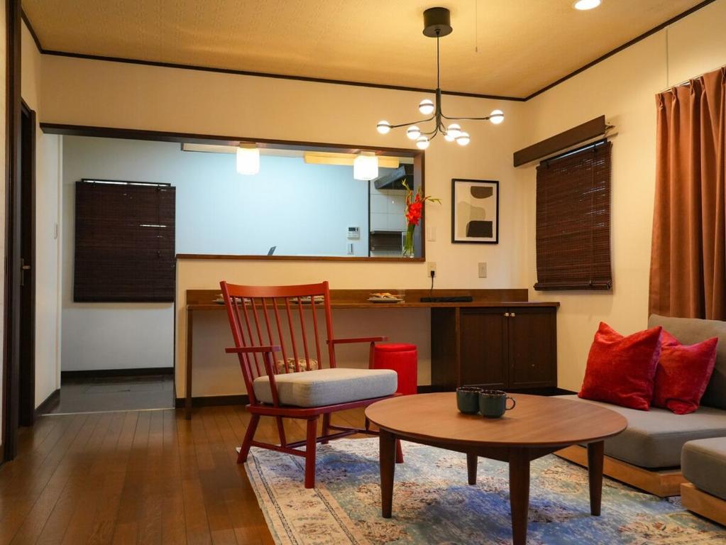 een woonkamer met een bank en een tafel bij ラフィーネハイツ 103 in Fuchu