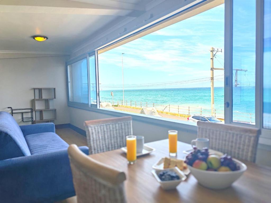 a living room with a table and a view of the ocean at Ocean Blue Stay in St James