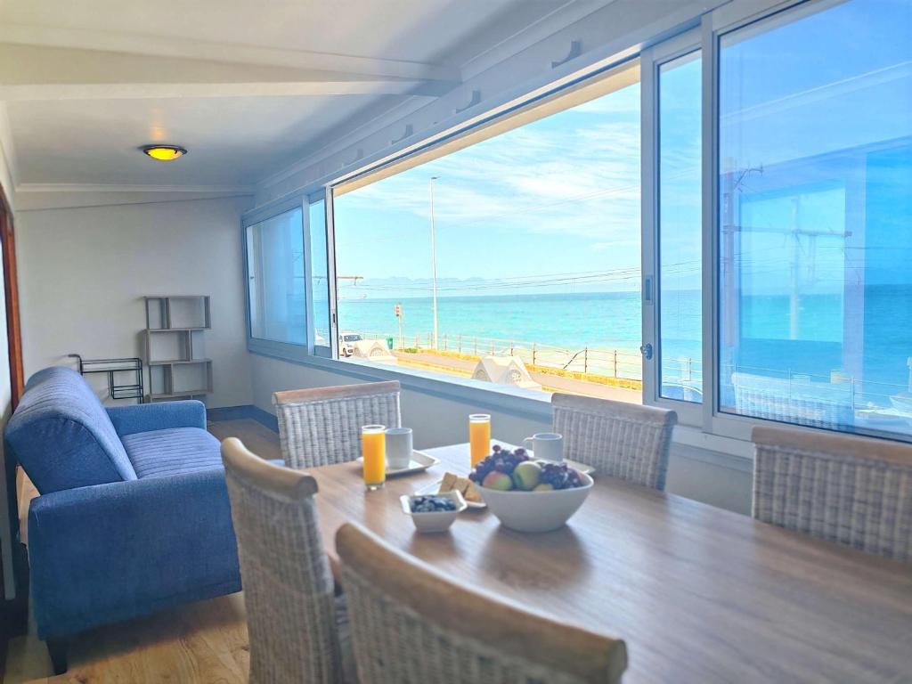 een eetkamer met een tafel en uitzicht op de oceaan bij Ocean Blue Stay in St James