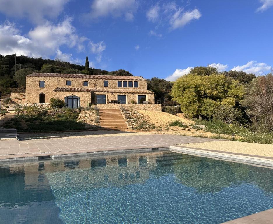 ein Haus mit einem Swimmingpool vor einem Gebäude in der Unterkunft Mimosa Lodge in Girona