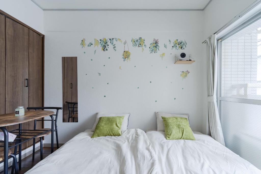 a bedroom with two beds and a table and a window at 3 minutes walk from Minami Fukuoka Station, free Wi-Fi in Fukuoka