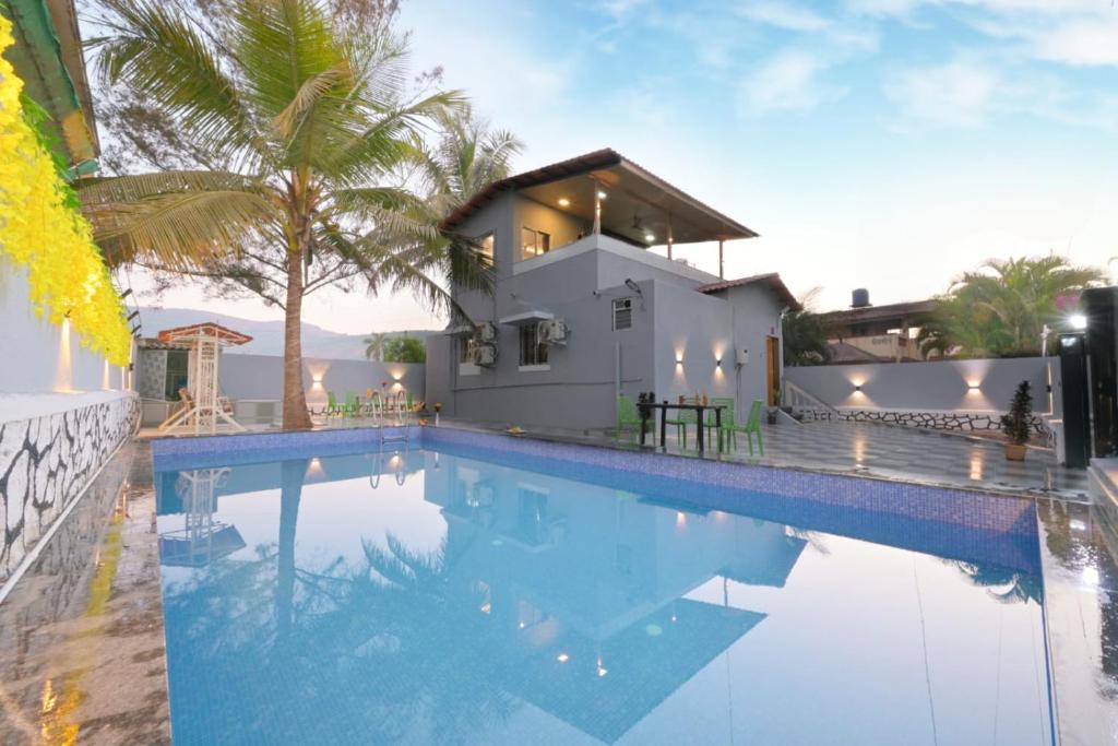 a swimming pool in front of a house at EMPYREAN STAYS ll 3bhk AC MARSHAL VILLA ll in Lonavala