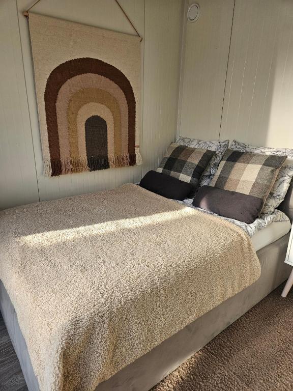 a bedroom with a bed with a painting of a rainbow at Strefa relaxu u JJ in Powałki