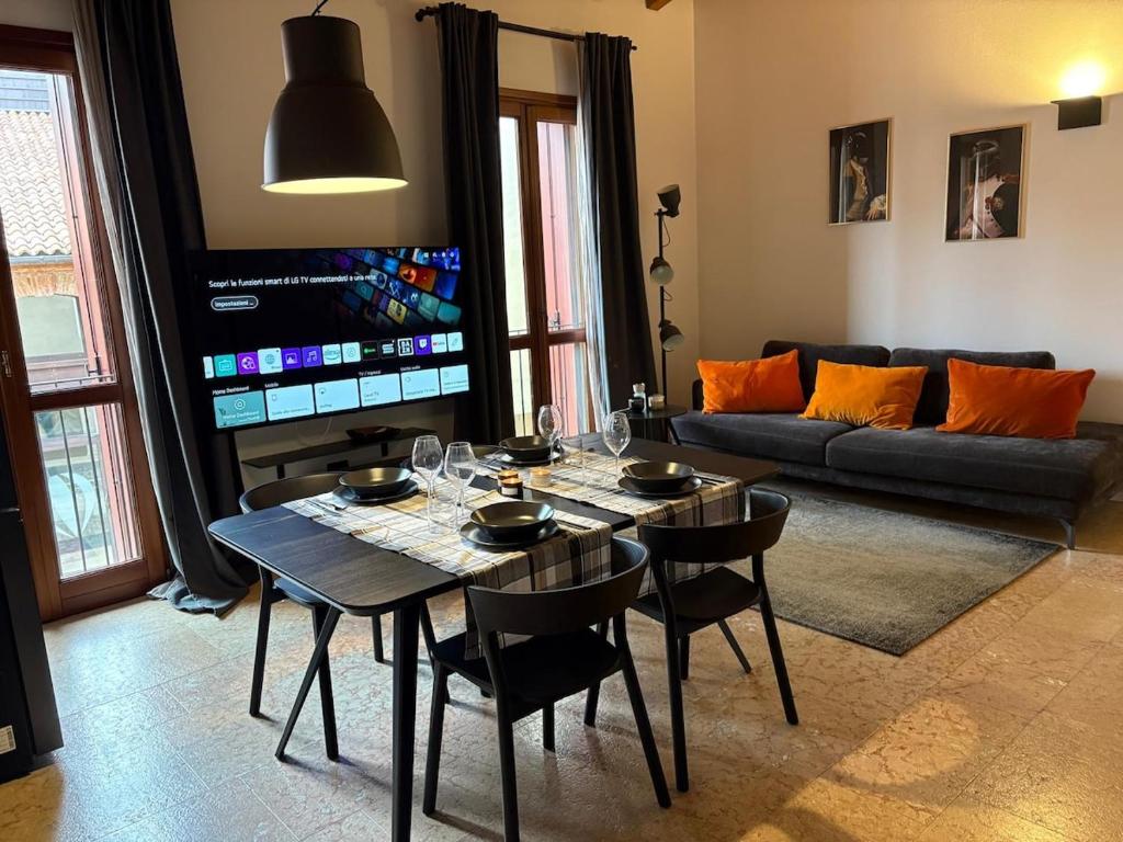 a living room with a table and a couch at Elegante appartamento nel cuore di Bassano in Bassano del Grappa