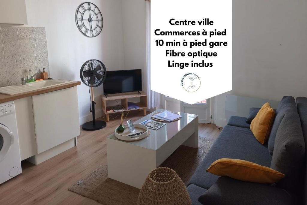 a living room with a blue couch and a table at L'esprit Cyrano in Bergerac