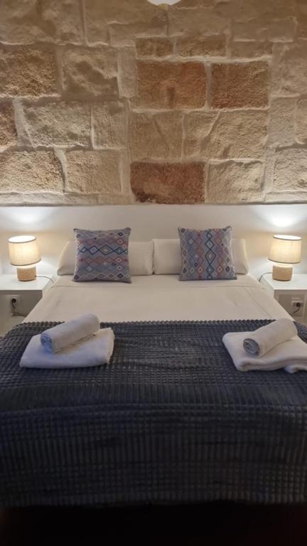 a bedroom with a large bed with towels on it at Hostel Menorca in Ciutadella