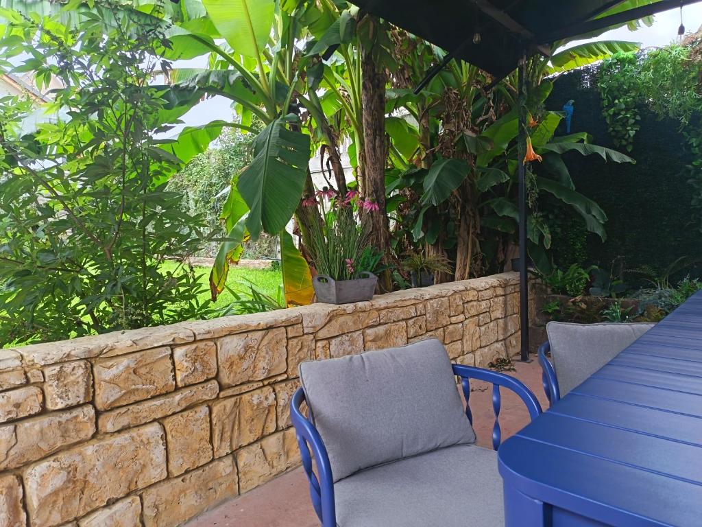 a patio with two chairs and a table and a brick wall at Cozy Cottage - Free Parking, Self Check-in in Oradea