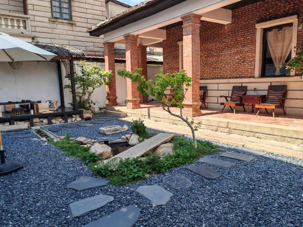 een huis met een tuin met rotsen ervoor bij Not just Tea Space in Quanzhou