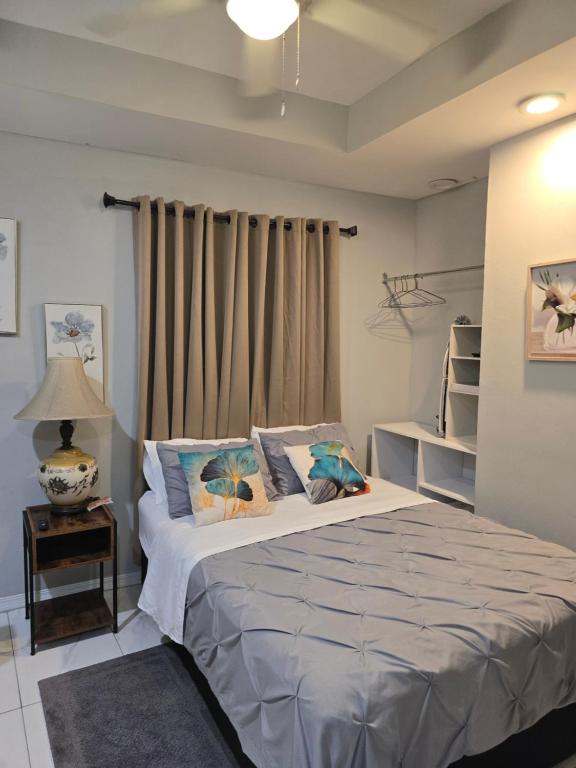 a bedroom with a bed and a lamp on a table at El Rincón in Tunapuna