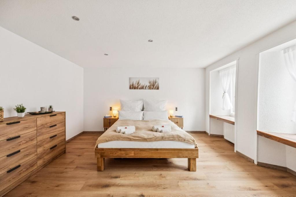 a white bedroom with a bed and a dresser at Altstadtidyll am See 1 - 6 Personen I Ruhig - Balkon - Parkplatz - nahe Bahnhof und Autobahn in Weesen