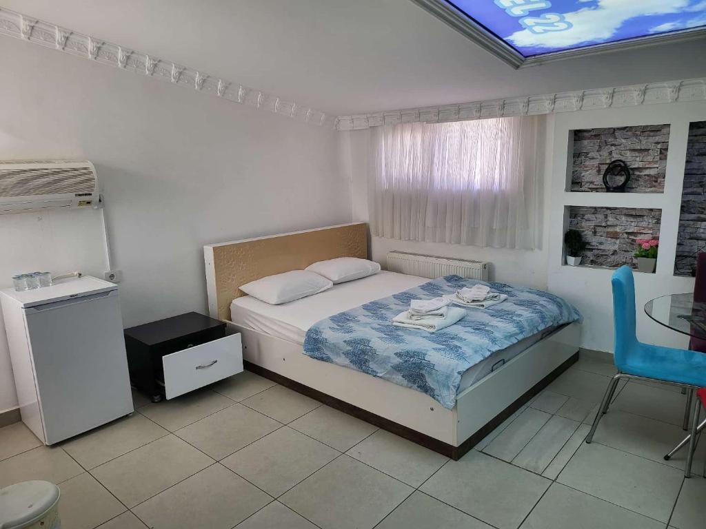 a bedroom with a bed and a blue chair at Home 22 Otel in Edirne