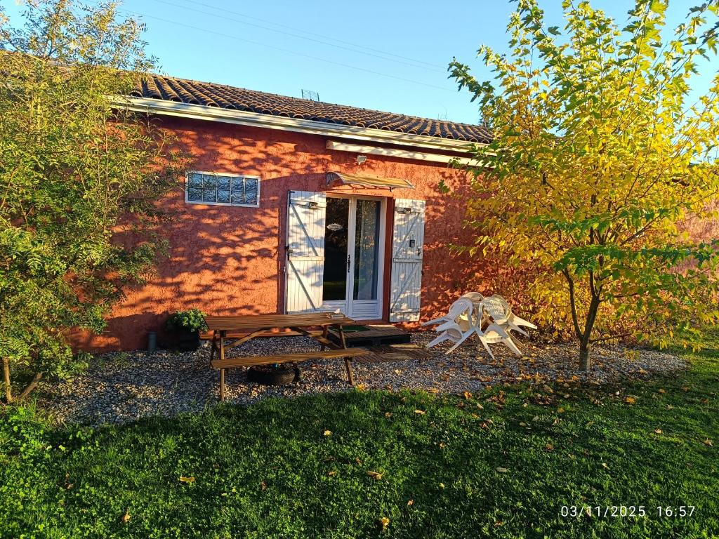 a small brick house with a bench in front of it at Maison Datcha Gîte familial avec jardin et piscine privée près de Toulouse in Lavaur