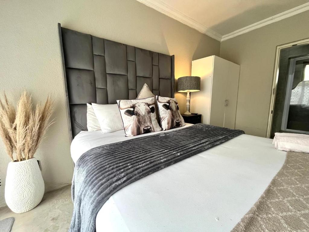a bedroom with a large bed with a large headboard at OR Tambo Stay Unit 1 in Boksburg