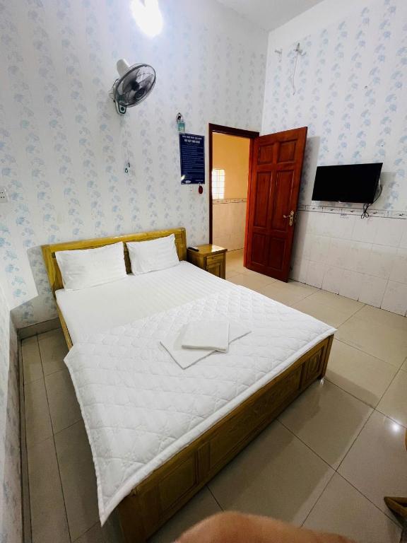 a bedroom with a large bed with a tv on the wall at Phát Đại Nam Motel in Xóm Hóc