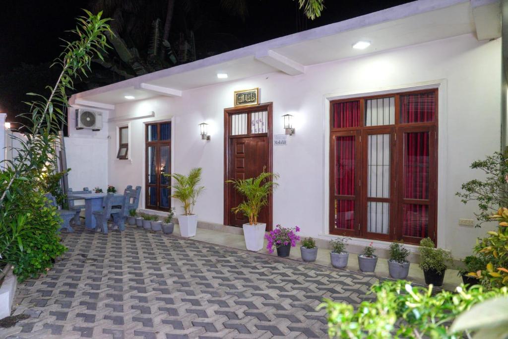 une maison avec une cour ornée de plantes en pot dans l'établissement Aru Villa Galle, à Galle