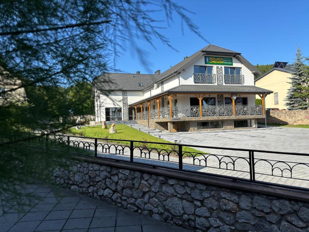 a large house with a fence in front of it at Resursa Chęcina Restauracja & Browar & Noclegi in Chęciny
