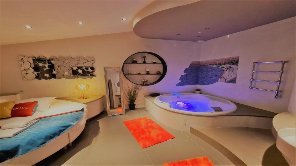 a bedroom with a bed and a bath tub at La Chaize - Villa, Suites & Spa in Noirmoutier-en-l'lle