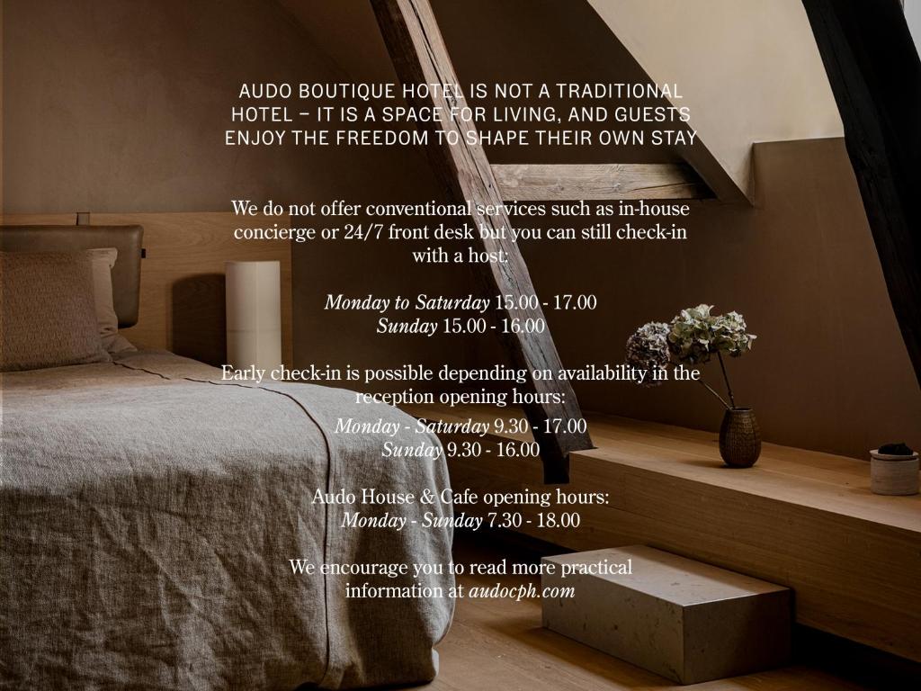 a bedroom with a bed and a wall with a poem at Audo Boutique Hotel in Copenhagen