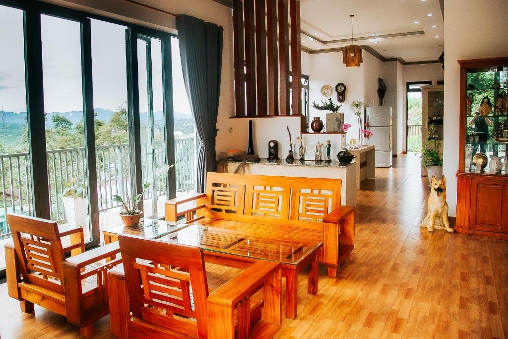cocina con mesa y sillas y ventana grande en Villa Hồng Phúc, en Ấp Thiện Lập