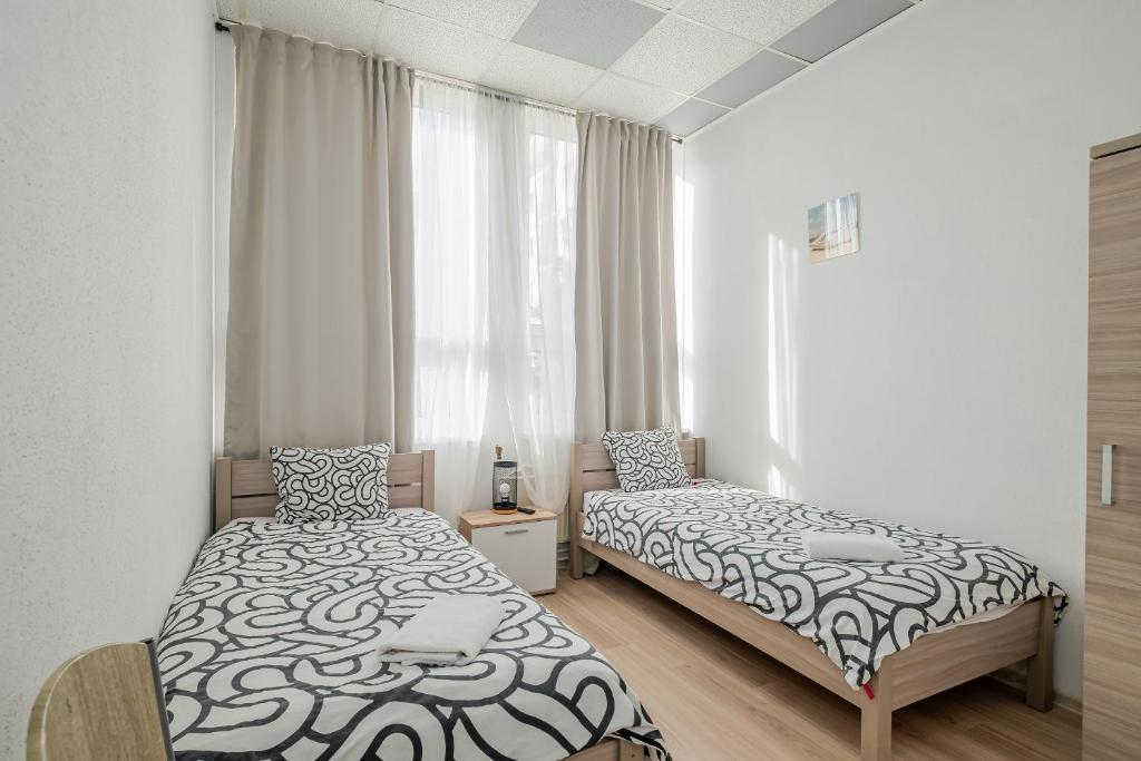 a bedroom with two beds and a window at Hostel Gdynia - Pokoje 2-osobowe na wyłączność in Gdynia