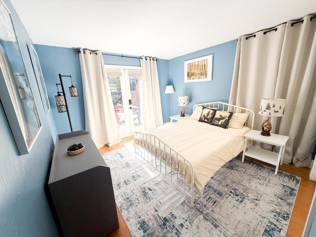 a blue bedroom with a bed and a window at Moki Pines Chalet - Stylish Stay Among the Pines in Flagstaff