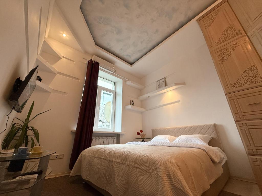 a bedroom with a bed and a window at Kyiv Sky Apartment in Kyiv
