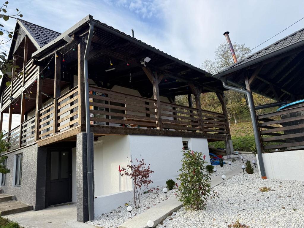 Una casa con una gran terraza a un lado. en Cabana cu Livada, en Mintiu Gherlii