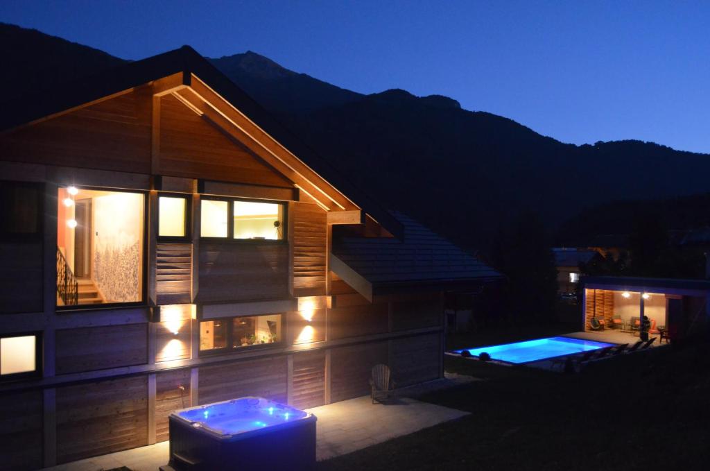 une maison avec piscine la nuit dans l'établissement Chalet neuf, Jacuzzi, piscine privée mai-sept, pétanque, proche Paradiski, à Aime La Plagne