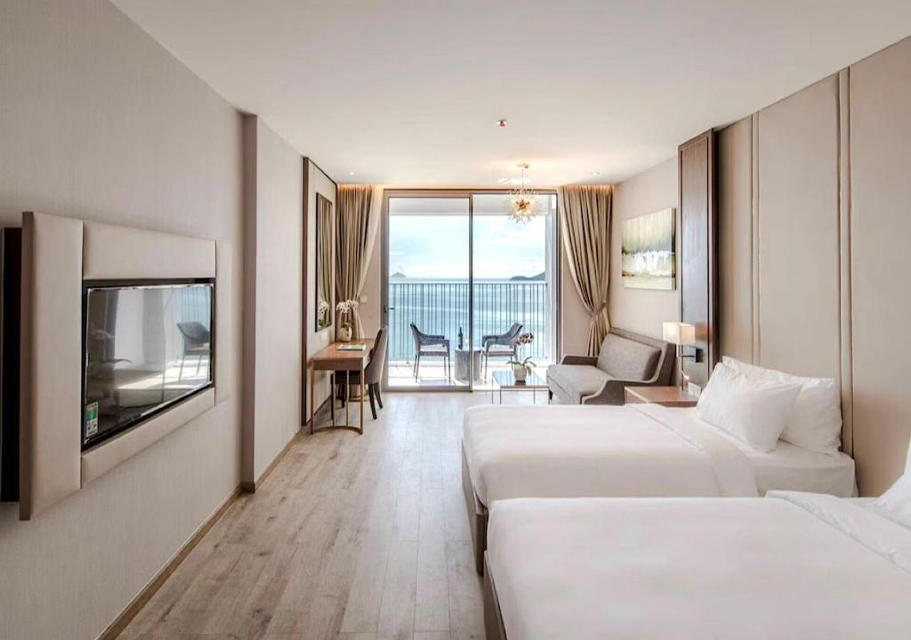 a hotel room with two beds and a living room at Panorama Sky Beach Recidences in Nha Trang