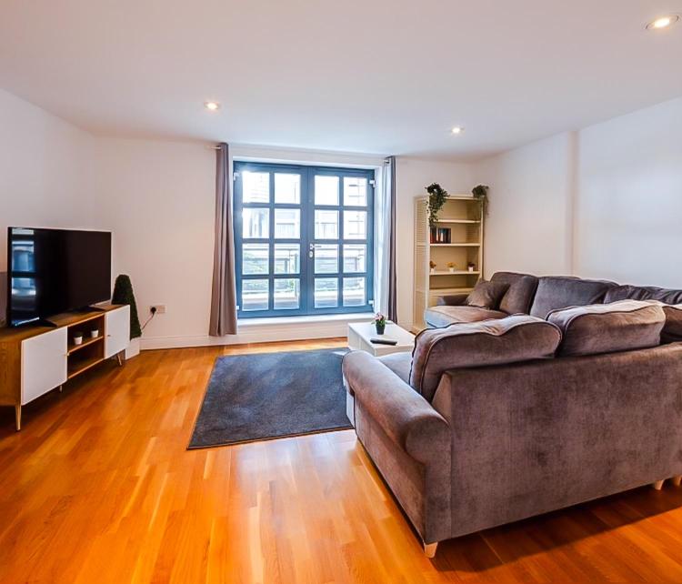 a living room with a couch and a television at Central 2BR flat - free parking - fast Wi-Fi in Bristol