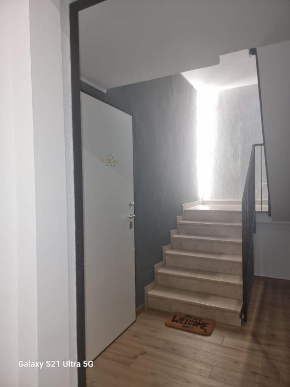 a hallway with a stairway with a door and a stairwayngth at Foresteria Alcatraz in Arluno