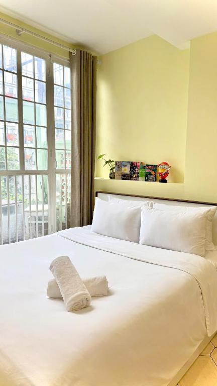 a white bed in a room with a large window at Hanoi Brilliant Home in Hanoi