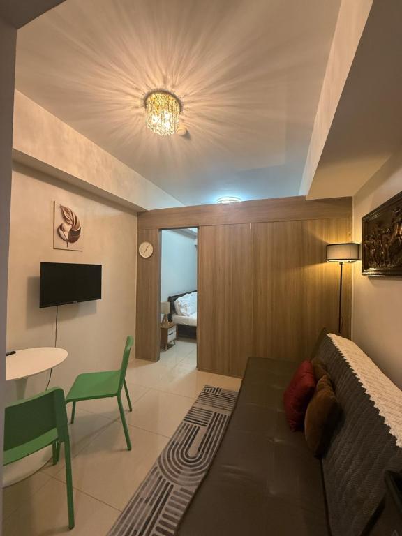 a bedroom with a bed and a table and a couch at Elresa Elegant at Field Residences Condominium Hotel in Manila