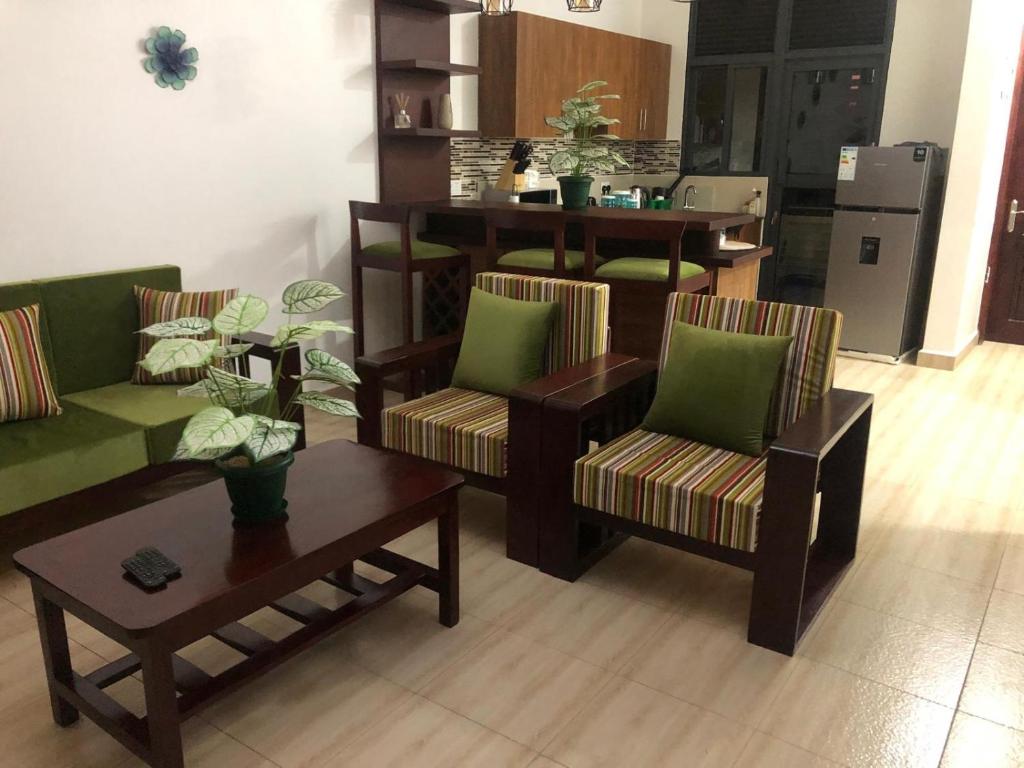 a living room with two chairs and a table at Neema maison de Glamour in Entebbe