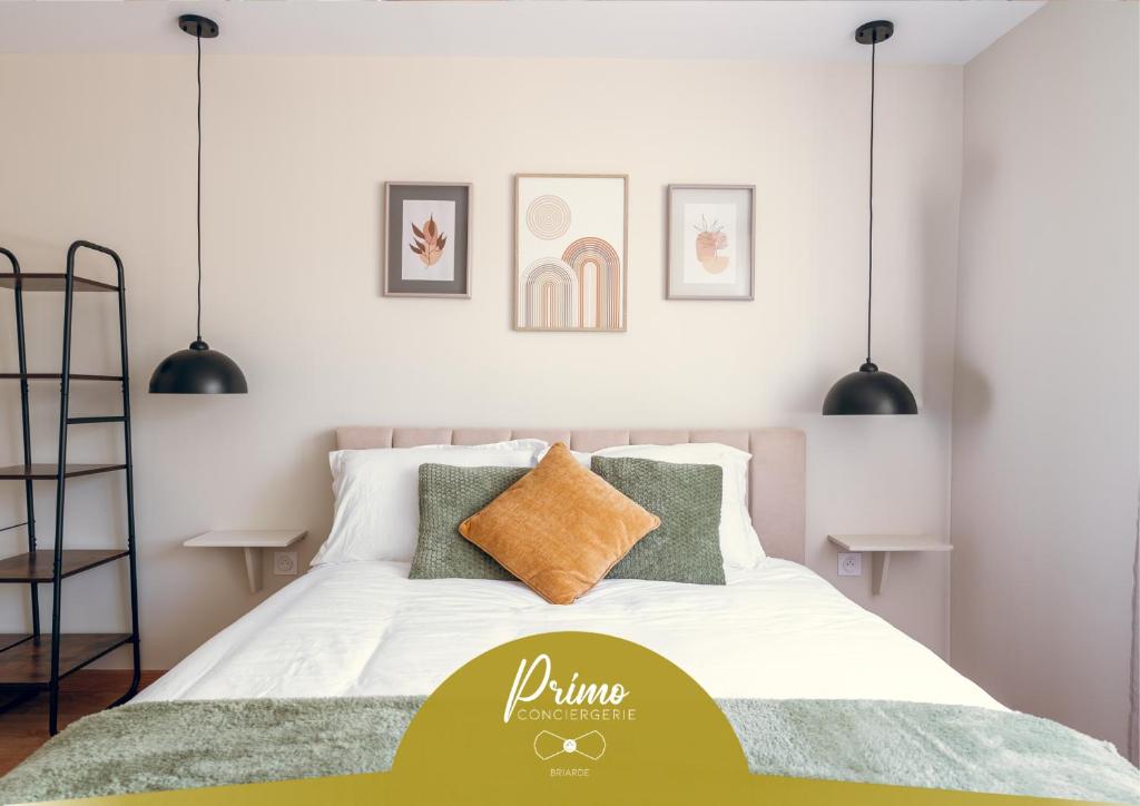 a bedroom with a bed with white sheets and green pillows at L'essentiel, calme et climatisé - Accès autonome in La Ferté-Gaucher