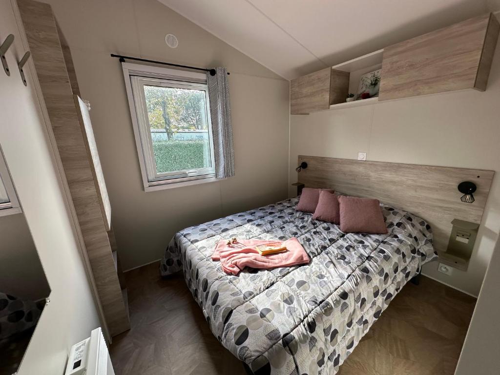 a bedroom with a bed and a window at Mobilhome neuf au camping La Réserve in Gastes