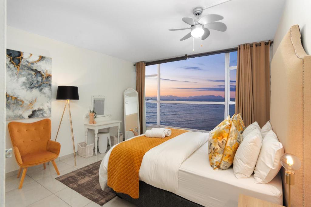 Un dormitorio con una cama y una ventana grande en Seaside Sunsets, en Strand