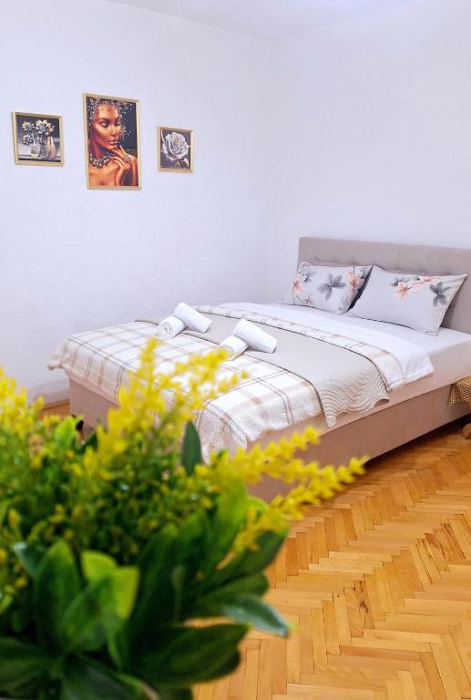 a bed in a room with pictures on the wall at TI-NI Apartment in Gevgelija