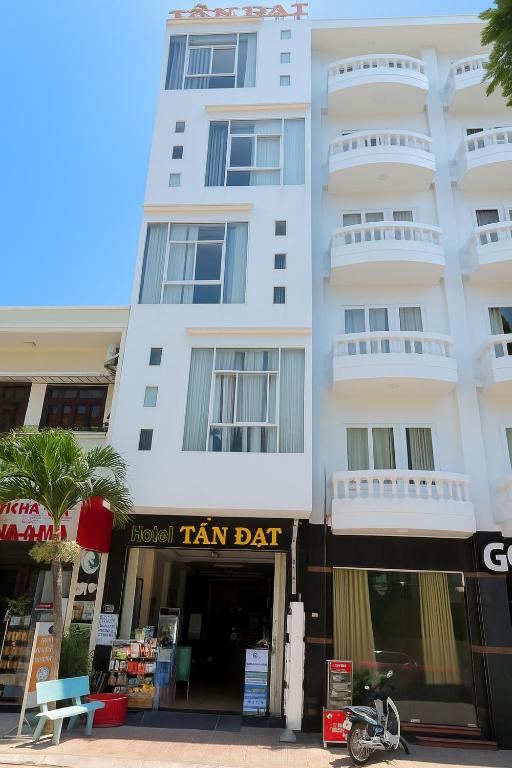 a tall white building with a tan dat sign in front of it at Tấn Đạt Hotel Quy Nhơn in Quy Nhon
