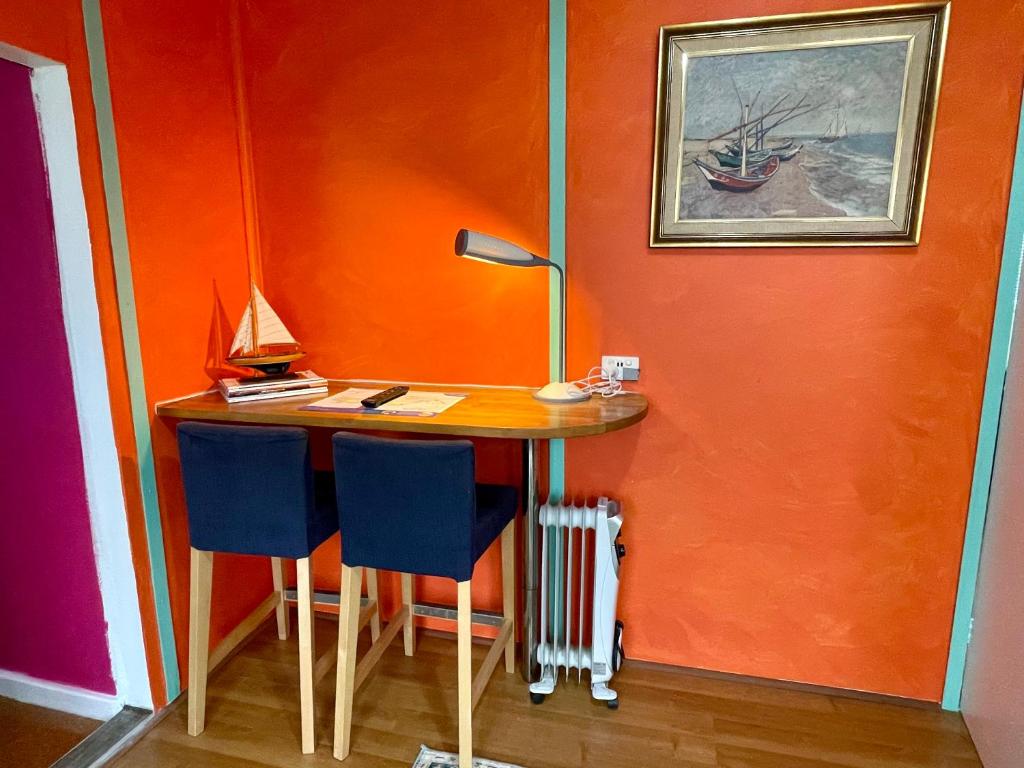 a desk with two chairs in a room with an orange wall at The Shanty in American River